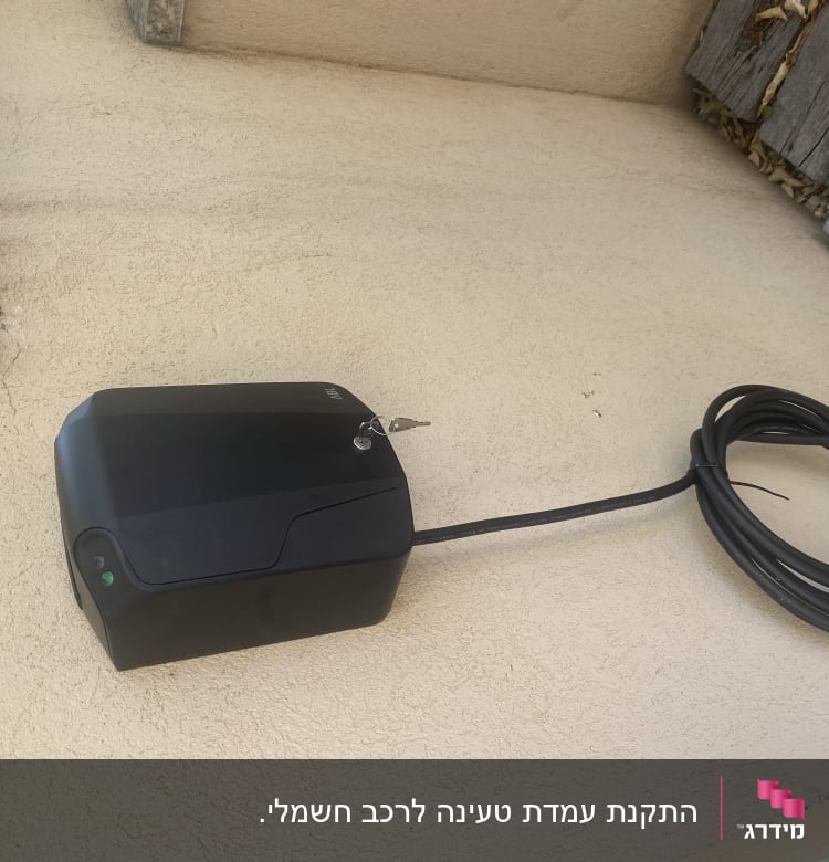 קופסת חשמל שחורה עם כבל חשמלי על קיר